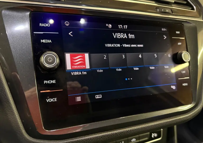 Écran tactile central du Volkswagen Tiguan 2018 affichant la radio VIBRA fm, entouré de commandes noires.