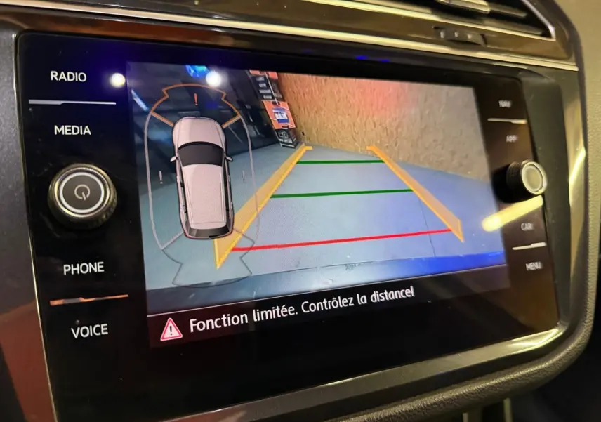 Écran tactile de caméra de recul du Volkswagen Tiguan 2.0 TDI gris montrant les lignes d’aide au stationnement.