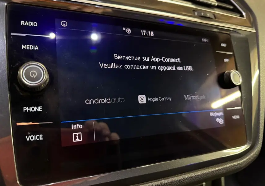Écran tactile central du tableau de bord du Volkswagen Tiguan gris, affichant l'interface App-Connect.