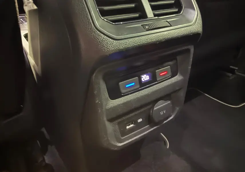 Détail de la console arrière du Volkswagen Tiguan gris montrant la climatisation et prises USB et 12V.