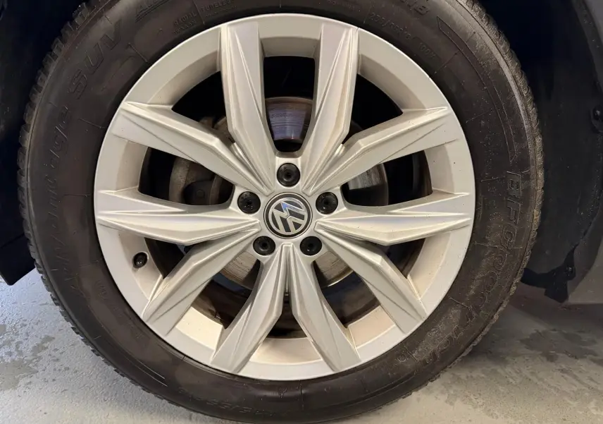 Gros plan sur la jante alu grise du Volkswagen Tiguan 2.0 TDI 150 DSG Carat Exclusive, avec logo VW au centre.