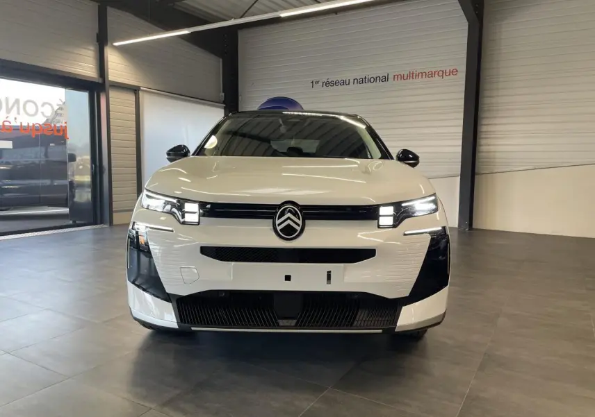 Vue avant d'un Citroën C5 Aircross blanc Okenite avec toit noir et calandre noir brillant en showroom.