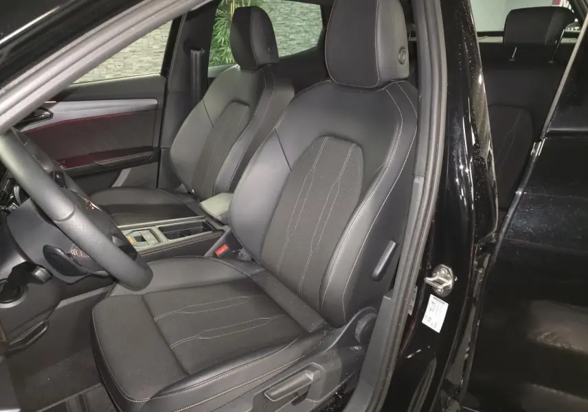 Vue intérieure côté conducteur du CUPRA Formentor noir 2025, sièges sport bimatière avec surpiqûres contrastantes.