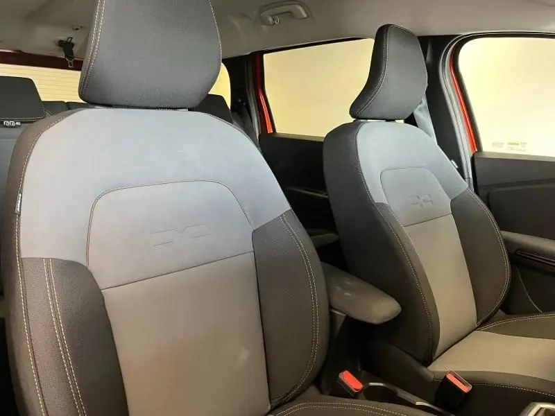 Gros plan sur les sièges avant gris et noirs du Dacia Jogger 2024 avec accoudoir central visible côté droit.