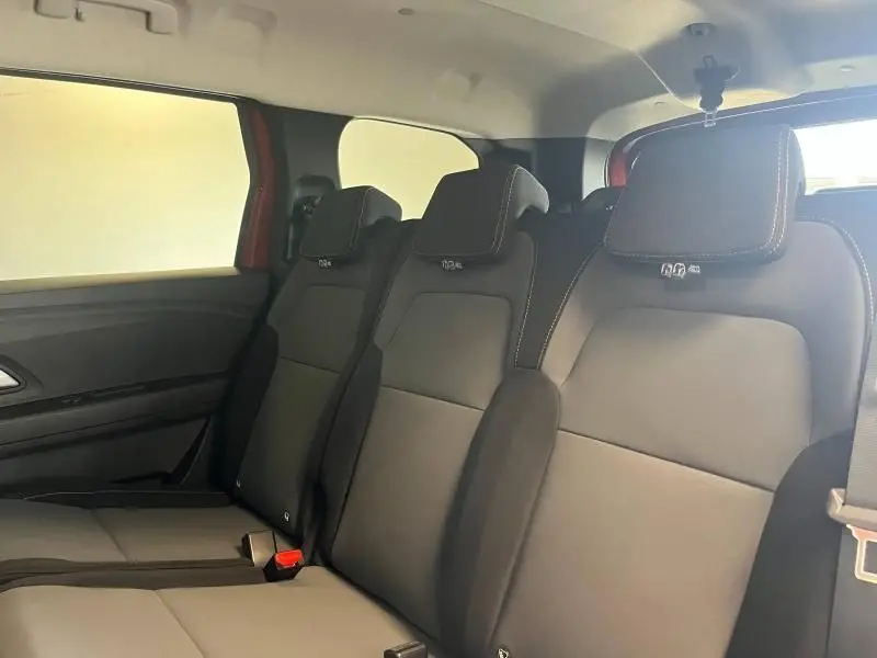Vue intérieure sur la banquette arrière 3 places du Dacia Jogger 2024 en tissu gris avec appuie-têtes intégrés.