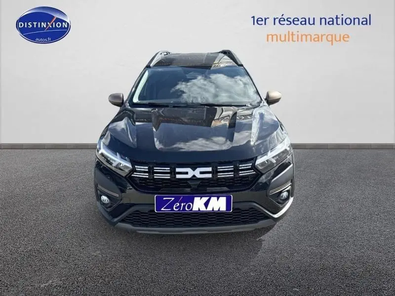 Vue frontale d'un Dacia Jogger 2024 noir nacré métallisé avec calandre marquée et phares LED allumés.