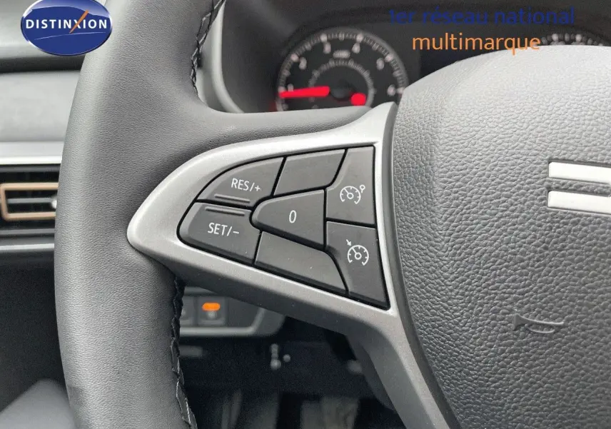 Gros plan sur les commandes au volant à gauche du Dacia Jogger 2024 noir nacré, avec tableau de bord en arrière-plan.