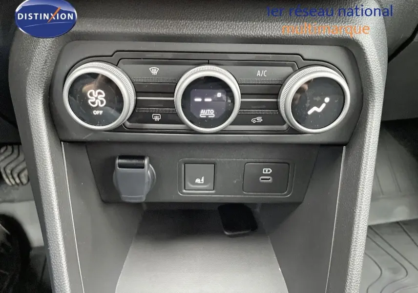 Gros plan sur la console centrale du Dacia Jogger 2024, montrant les commandes de climatisation et prises USB.