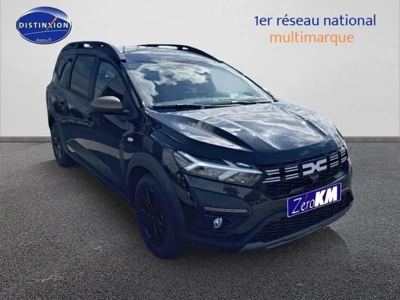 Dacia Jogger noir nacré métallisé en 3/4 avant droit avec barres de toit et jantes noires.