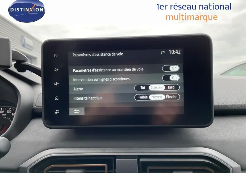 Vue intérieure centrée sur l'écran tactile du tableau de bord du Dacia Jogger 2024, affichant les réglages d'assistance de voie.