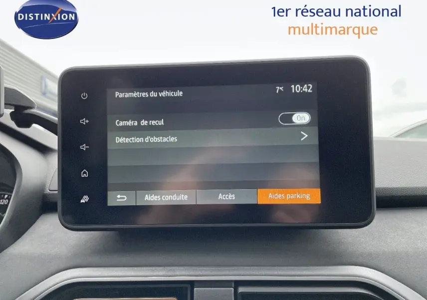 Vue intérieure centrée sur l'écran tactile du tableau de bord du Dacia Jogger noir nacré, affichant les aides au parking.