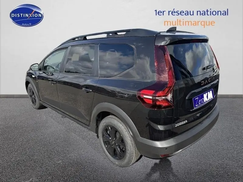 Vue 3/4 arrière droite d'un Dacia Jogger noir nacré métallisé avec barres de toit et jantes noires.