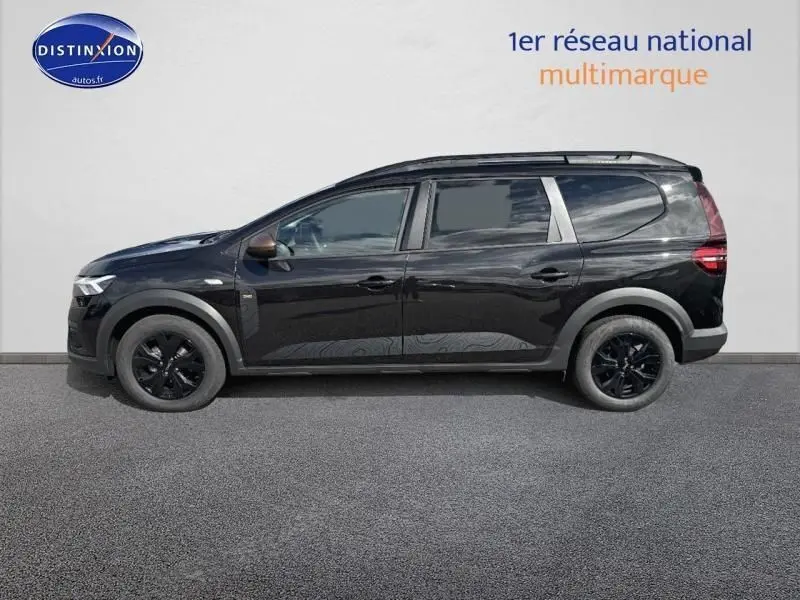 Profil droit d'un Dacia Jogger 2024 noir nacré métallisé avec barres de toit et jantes noires.