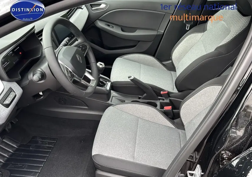 Intérieur avant droit de la Renault Clio V noire 2025 avec sièges gris clair et volant multifonction.