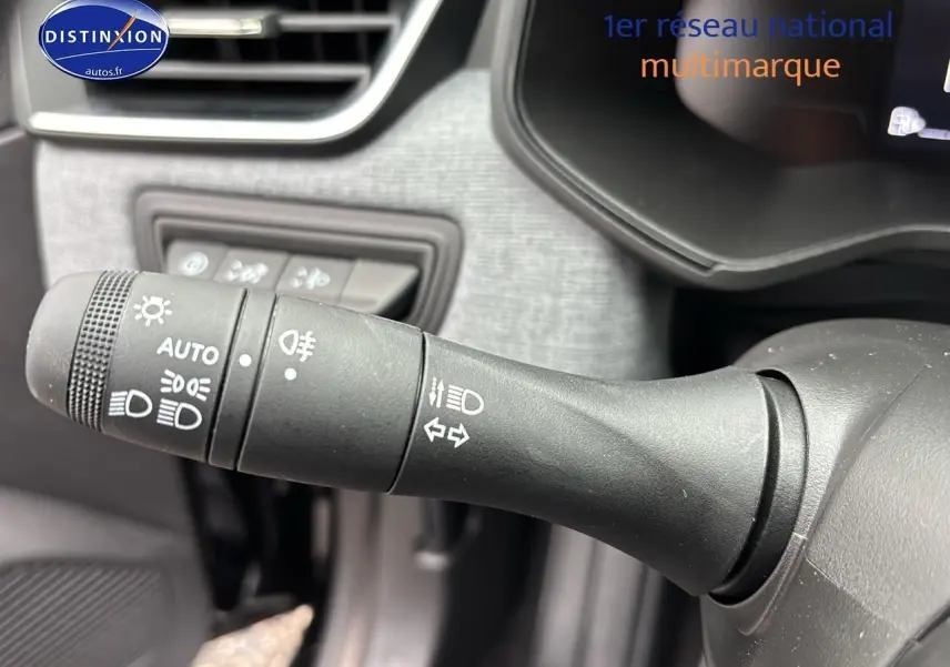 Le commodo d'éclairage noir du tableau de bord d'une Renault Clio V diesel 2025, avec commandes lumineuses visibles.