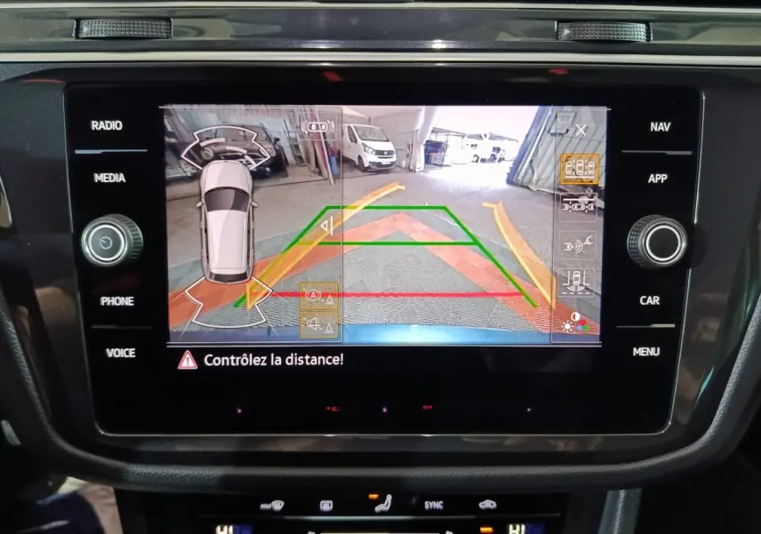 Écran tactile intérieur du Volkswagen Tiguan 2021 montrant la caméra de recul avec guidage dynamique en couleurs.