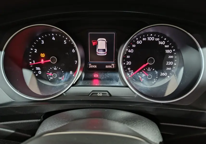 Vue rapprochée du tableau de bord du Volkswagen Tiguan bleu, affichant compte-tours, vitesse et alertes ouvertes.