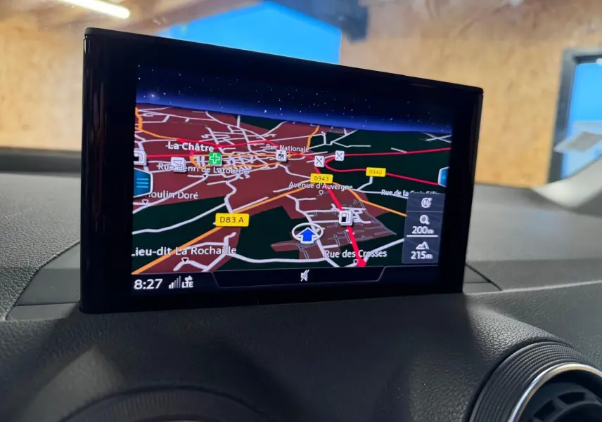 Écran GPS couleur intégré au tableau de bord de l'Audi Q2 gris, vue intérieure centrée sur la navigation.