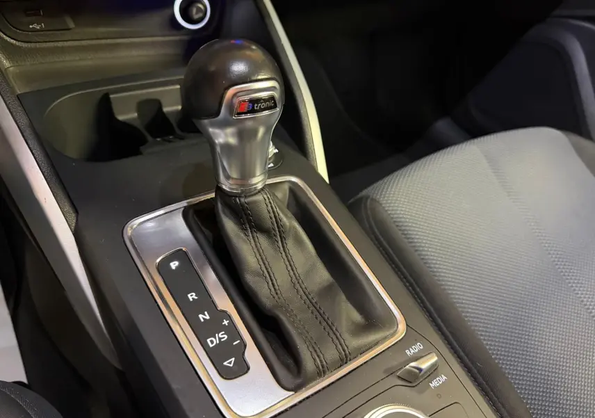 Gros plan sur le levier de vitesse automatique S-Tronic et siège tissu gris de l'Audi Q2 1.0 TFSI Business Design.