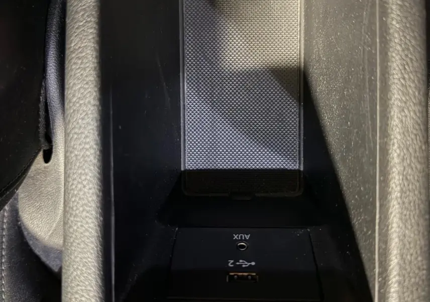 Vue rapprochée de la console centrale noire de l'Audi Q2 2018 avec prise USB et entrée AUX intégrées.