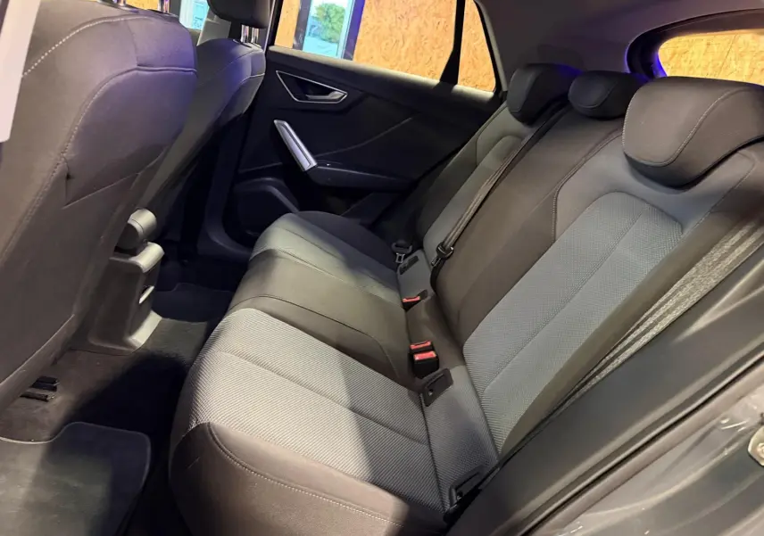 Vue intérieure côté droit de la banquette arrière grise de l'Audi Q2 2018 avec appuie-têtes et ceintures visibles.