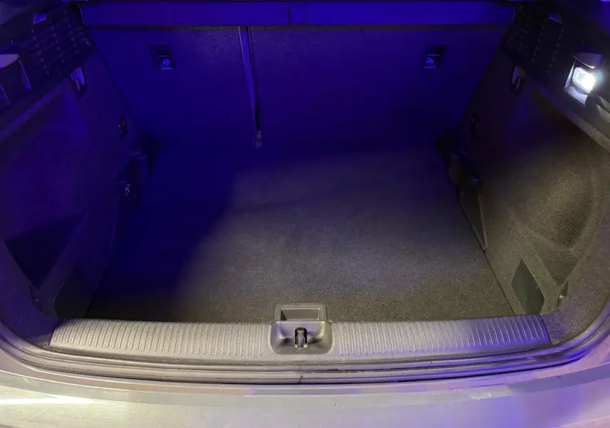 Coffre ouvert d'Audi Q2 gris vu de l'arrière, montrant un espace de chargement propre et éclairé.