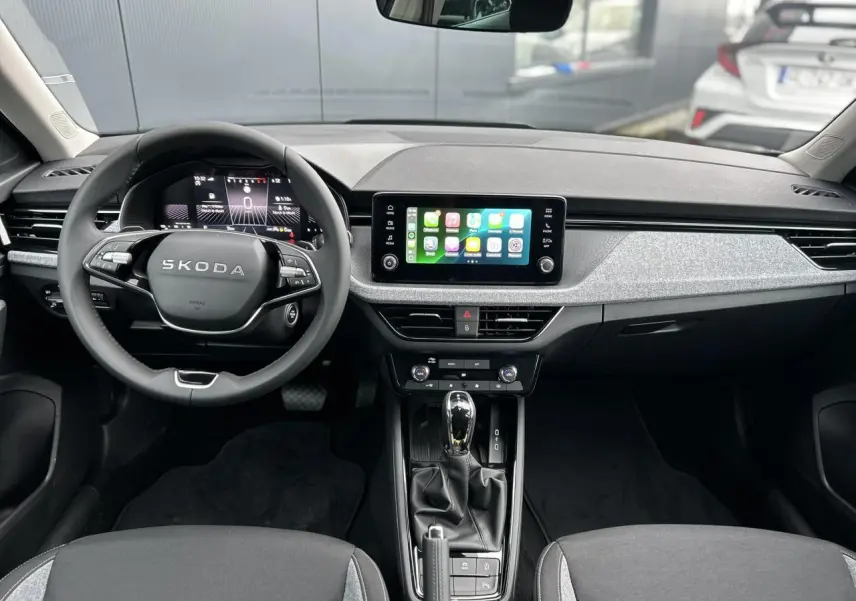 Vue intérieure frontale du tableau de bord du Skoda Kamiq noir, avec écran tactile Apple Car Play et volant multifonctions.