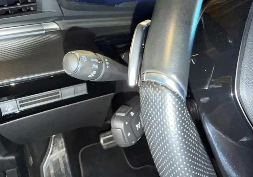 Gros plan sur le volant cuir perforé et les commandes derrière le volant du Peugeot 508 SW noir, intérieur noir Mistral.