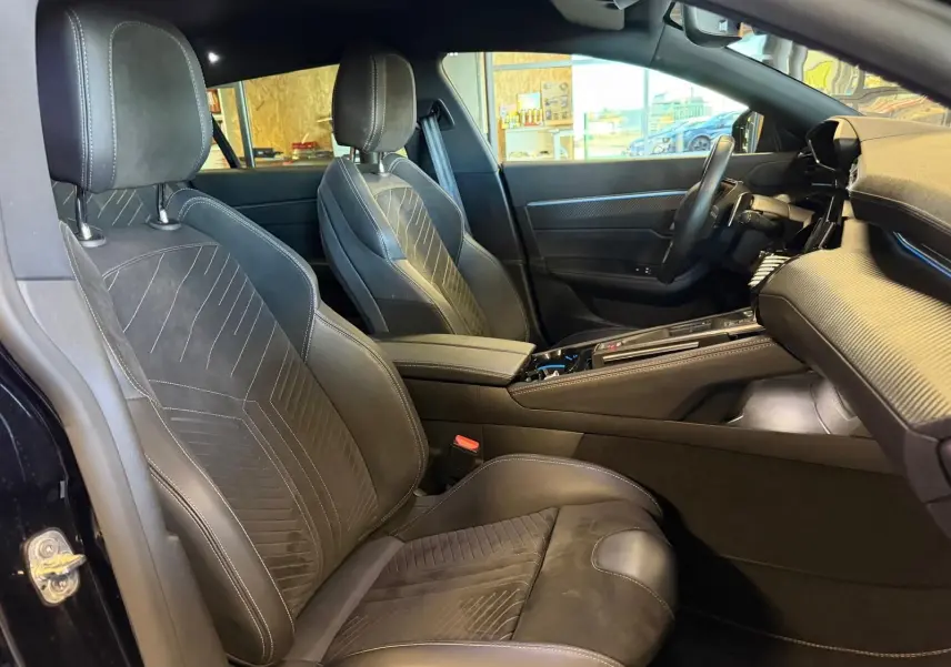 Vue intérieure côté conducteur de la Peugeot 508 SW noire, mettant en valeur les sièges Alcantara et la console centrale moderne.