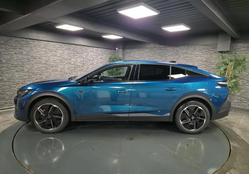 Profil droit d'une Peugeot 408 hybride rechargeable bleu métallisé, avec jantes alliage 19 pouces et vitres teintées.