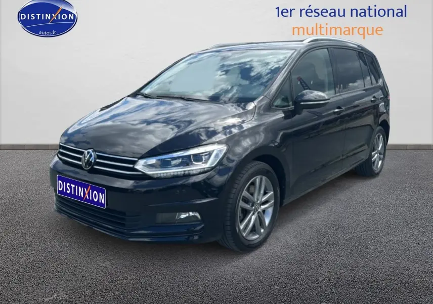 Volkswagen Touran noir 2025 en 3/4 avant droit, avec calandre chromée et jantes alu visibles.