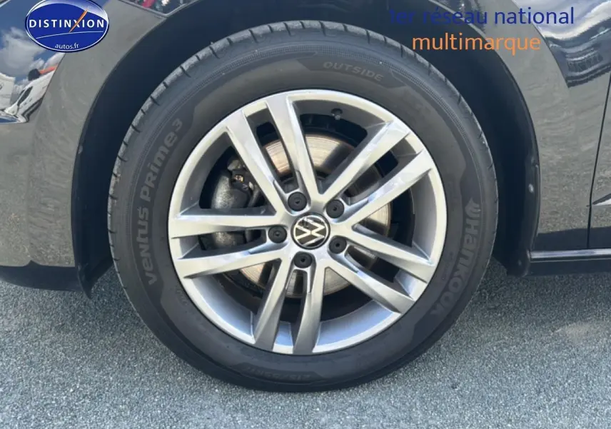 Gros plan sur la roue avant droite alu argentée d’un Volkswagen Touran noir 2025 avec pneu Hankook.