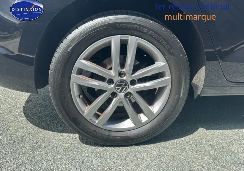 Gros plan sur la roue arrière droite d’un Volkswagen Touran noir avec jante alliage argentée.