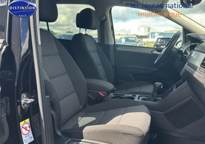 Vue intérieure côté gauche du Volkswagen Touran noir 2025, montrant les sièges avant et la console centrale.