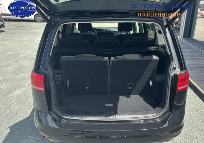 Vue arrière du Volkswagen Touran noir 2025 avec coffre ouvert et troisième rangée de sièges visibles.