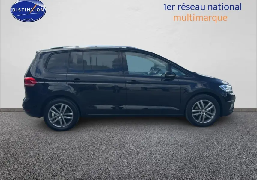 Profil côté gauche d'un Volkswagen Touran noir 2025 avec barres de toit et jantes alliage.