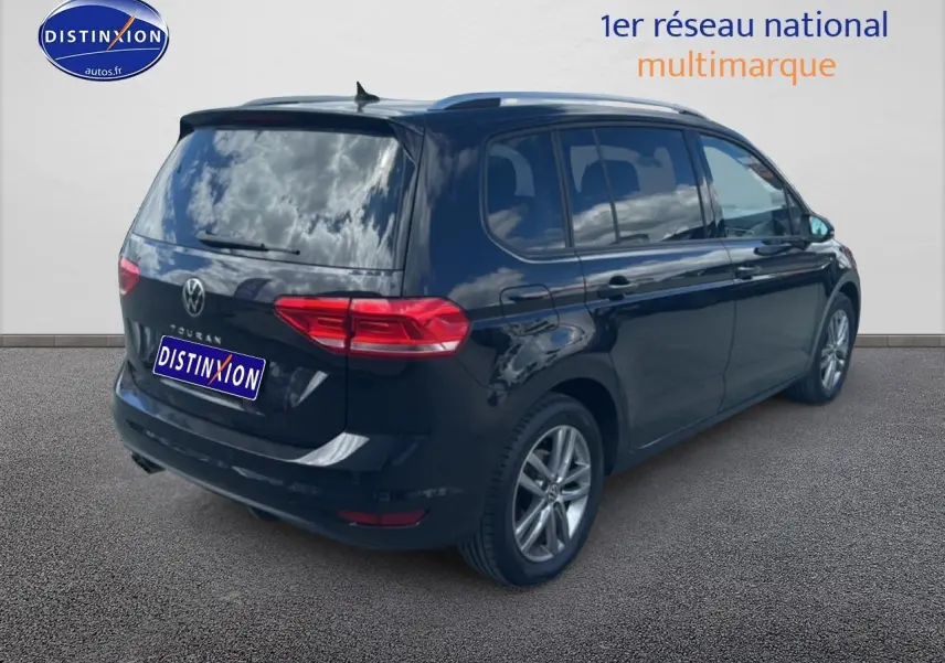 Vue 3/4 arrière droite d'un Volkswagen Touran noir 2025 avec vitres surteintées et jantes alu.