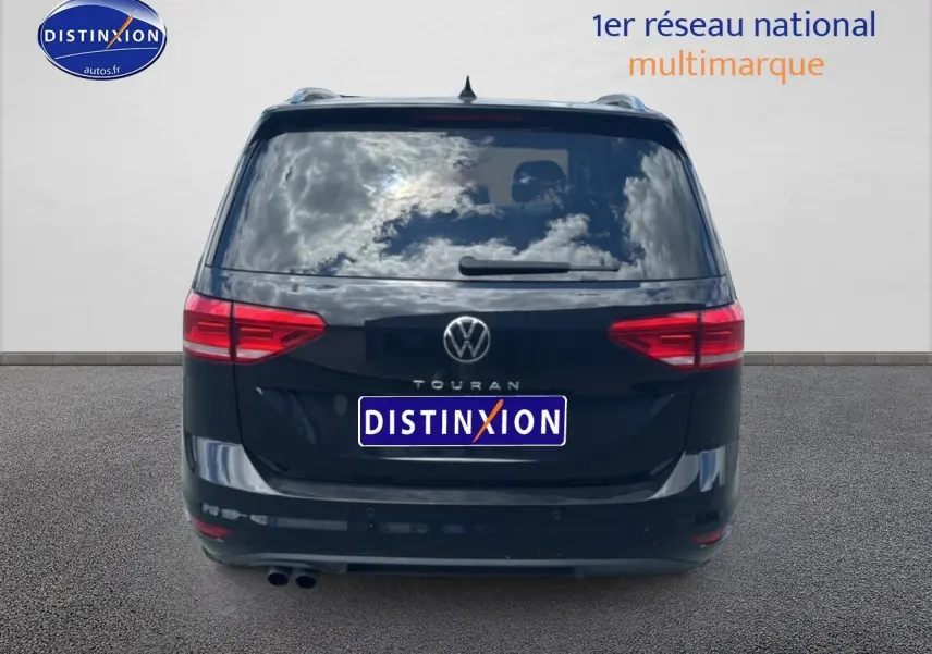 Vue arrière d'un Volkswagen Touran noir 2025 avec feux rouges et double sortie d'échappement visible.