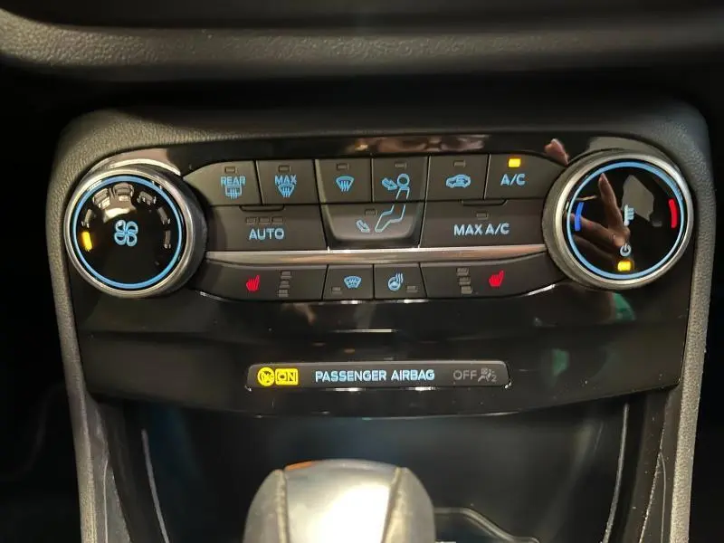 Gros plan sur la console centrale du Ford Puma 2021, boutons de climatisation et chauffage en noir brillant.