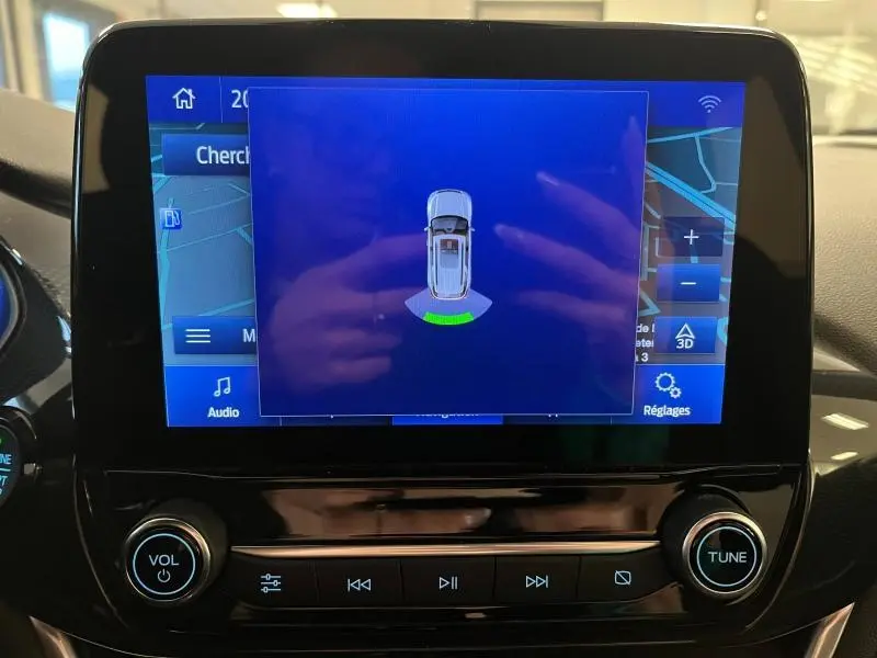 Écran tactile central du Ford Puma 2021 montrant l'aide au stationnement avec vue du dessus du véhicule.