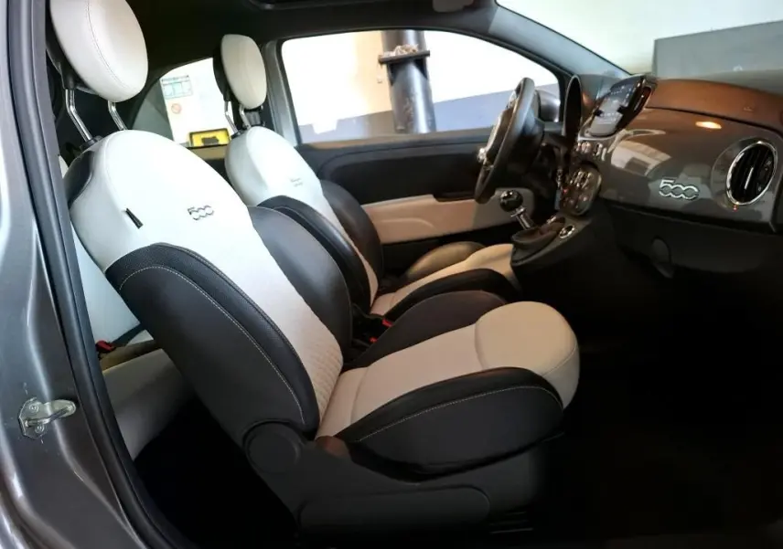 Vue intérieure côté gauche de la FIAT 500 2022 gris Electroclash, sièges bicolores noirs et blancs avec logo 500 brodé.