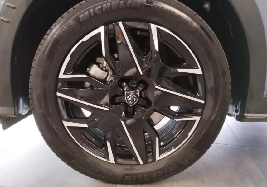 Gros plan sur la jante alliage noire diamantée 19'' avec logo Peugeot au centre, roue avant droite du 5008 Bleu Ingaro.