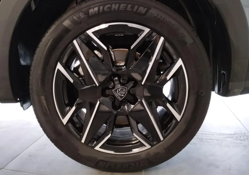 Gros plan sur la jante alliage 19'' noire et diamantée du Peugeot 5008 Bleu Ingaro, avec pneu Michelin visible.
