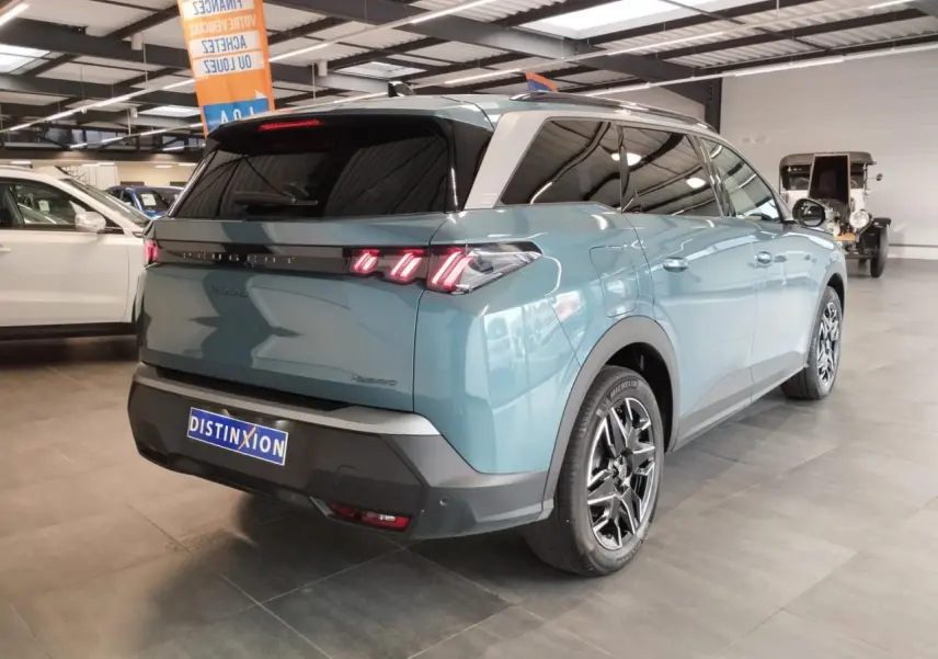 Vue 3/4 arrière droite d’un Peugeot 5008 bleu Ingaro avec feux arrière à LED 3 griffes et jantes alliage 19 pouces.