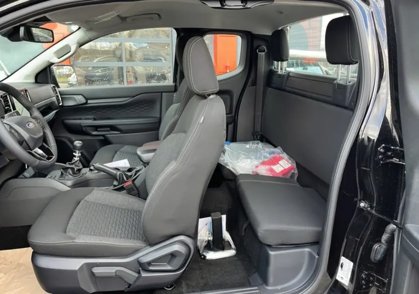 Vue intérieure côté gauche du Ford Ranger noir shadow 2025, montrant les sièges avant, banquette arrière et tableau de bord.