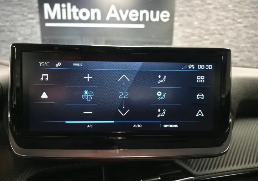Écran tactile central du tableau de bord du Peugeot 2008 1.2i Hybrid 2025 avec commandes climatisation affichées.