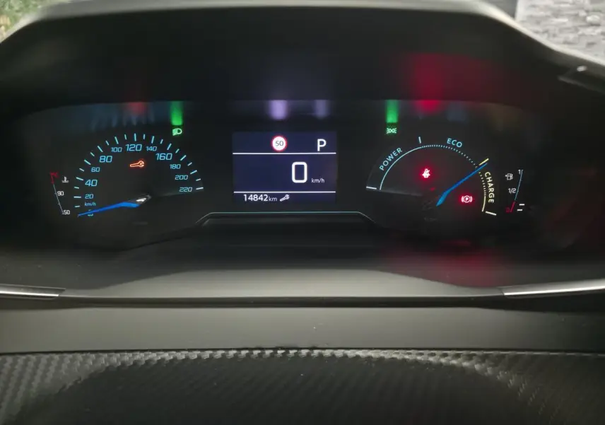 Vue rapprochée du combiné d'instruments numérique du Peugeot 2008 gris, affichant 0 km/h et 14842 km au compteur.