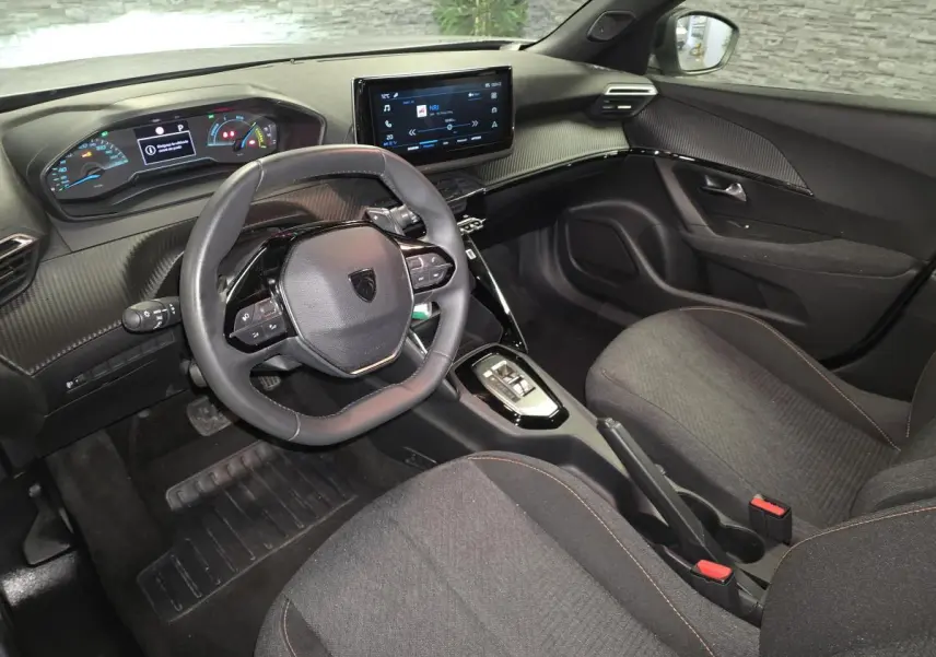 Intérieur avant du Peugeot 2008 gris, vue côté conducteur, avec tableau de bord numérique et écran tactile central.