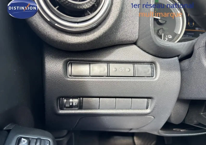 Détail intérieur côté gauche du tableau de bord du Nissan Juke 2024, avec commandes de réglage d’éclairage.