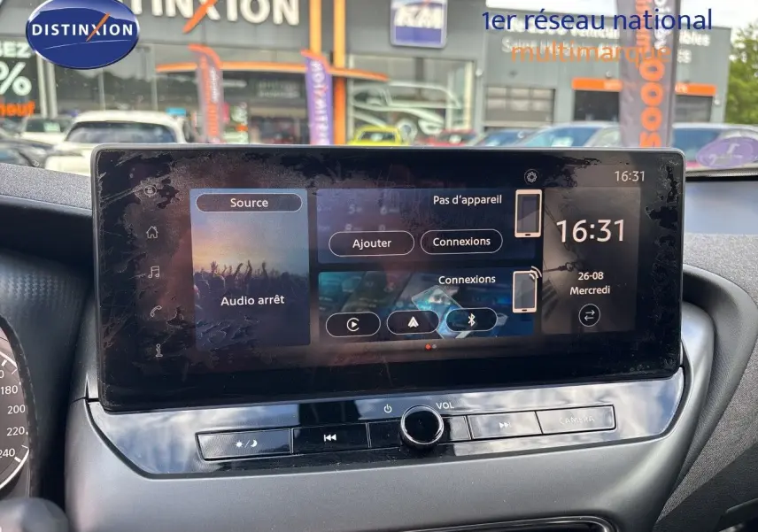 Vue rapprochée de l’écran tactile central du Nissan Juke Hybrid 2024 gris squale metal avec interface multimédia affichée.